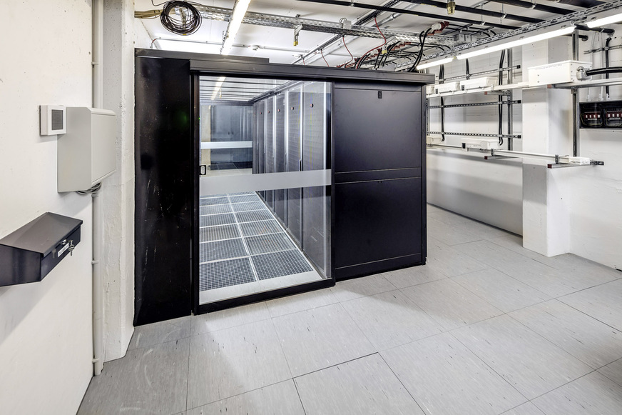 5 Die beiden Klimaschränke sind links und rechts an den Stirnseiten des Serverraumes aufgestellt. In der Mitte befinden sich sechs Racks&nbsp; mit dem neuen Rechner und seinen peripheren IT-Komponenten.