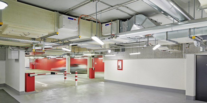 Bild 8: Der Vorteil des Systemverbundes aus einer Hand wird an dieser Installationssituation in der Tiefgarage besonders deutlich: Die Lüftungskanäle, die brandgeschützten Promat-Kanäle und auch die notwendigen Brandschutzklappen wurden von Systemair realisiert. Ebenso dutzende CO-Sensoren und Warnschilder, eine CO-Warnanlage und die werksseitig vorverdrahtete Steuerungstechnik.
