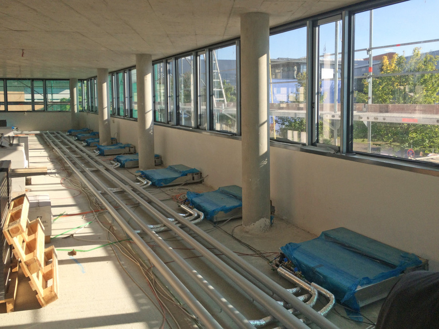Bild 4: Installation und Anbindung von FVPpulse-Fassaden­lüftungsgeräten in ­einem Bürogebäude mit Doppelboden.