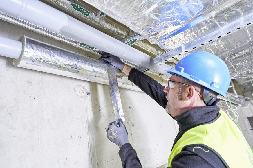 Bild 4 Die geschlitzte Teclit-PS-Cold-Rohrschale wird über die Leitung geschoben, die selbstklebenden Überlappungen der Aluminiumkaschierung werden mit einem Spatel glatt angedrückt. Stöße zwischen zwei Rohrschalen werden mit dem „Teclit Alutape“ sicher umwickelt und verklebt. Eine Sicherungsverklebung nach DIN 4140 bietet eine einfache Lagesicherung.