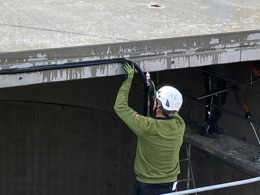 Bild 12 Einbau der EPDM-Dichtung im Elementstoß zwischen den Betonfertigteilen des thermischer Pufferspeichers. Nach Fertigstellung ist der 500 m3 fassende Behälter befahrbar bei einer Lastverteilung mit mindestens 50 cm Überdeckung.