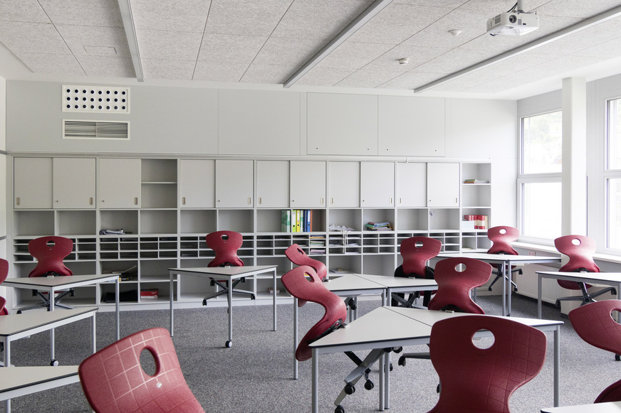 Bild 1 Schullüftung quasi ohne Raumverlust: An der hinteren Wand sind von der dezentralen Anlage mit einem FVS-Eco2School-600-Gerät (LTG) lediglich die Luftdurchlässe (links) und die Revisionsklappen (rechts über der Regalwand) zu erkennen und …