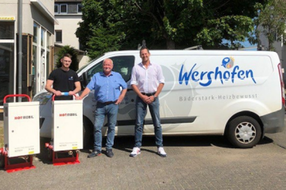 V.l.n.r.: Marcel Wershofen (Installateur- und Heizungsbaumeister, Wershofen GmbH), Frank Wershofen (Geschäftsführer, Wershofen GmbH) und René Wagemann (Außendienstmitarbeiter, Hotmobil) mit den von Hotmobil bereitgestellten mobilen Elektroheizzentralen auf dem Firmengelände der Wershofen GmbH.