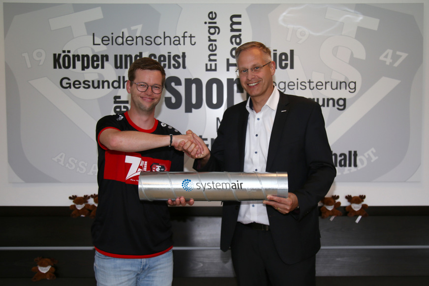 Zur offiziellen Übergabe überreicht der Geschäftsführer von Systemair, Stefan Fischer, ein Kanalteil an den 1. Vorsitzenden des TSV Assamstadt, Christian Hügel.