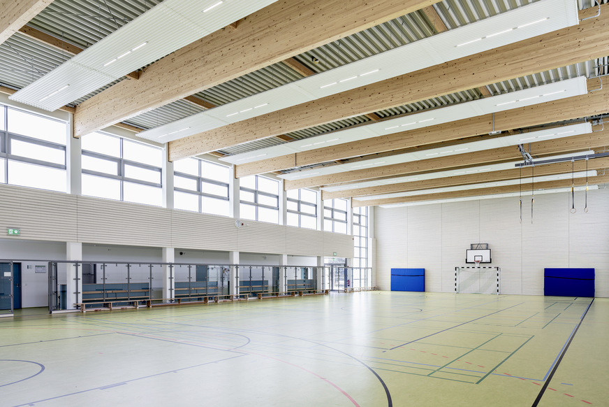 Bild 2 Beheizt wird die Turnhalle über Deckenstrahlplatten mit integrierten LED-Leuchten. Befestigt wurden sie mit einem Kettensystem, das an der Trapezfläche der Turnhallendecke fixiert wurde.