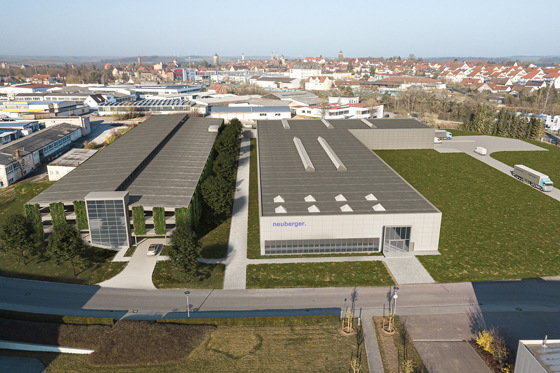 Die Visualisierung zeigt die beiden neuen Gebäude: links das Parkhaus, rechts daneben die Elektronikfertigung. Im hinteren Bereich der Logistikbereich mit separater Zufahrt. 