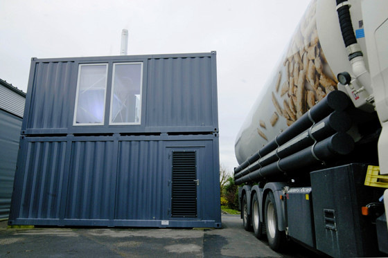 Die Wärmeerzeuger, Pufferspeicher und Pelletsilos befinden sich in zwei Containern, die direkt neben der Werkshalle stehen.