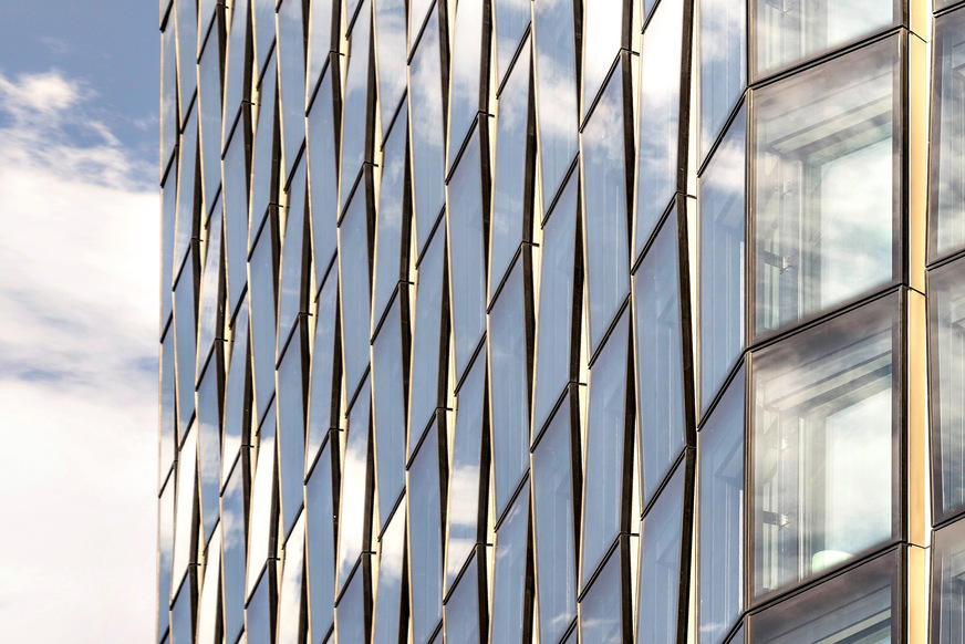 Bild 2 Spiel mit der Reflexion: Leicht gegeneinander verkippte Fassadenteile lassen unterschiedliche Ausschnitte von Stadt und Himmel sichtbar werden.