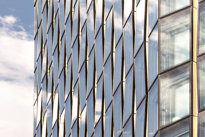 Bild 2 Spiel mit der Reflexion: Leicht gegeneinander verkippte Fassadenteile lassen unterschiedliche Ausschnitte von Stadt und Himmel sichtbar werden.