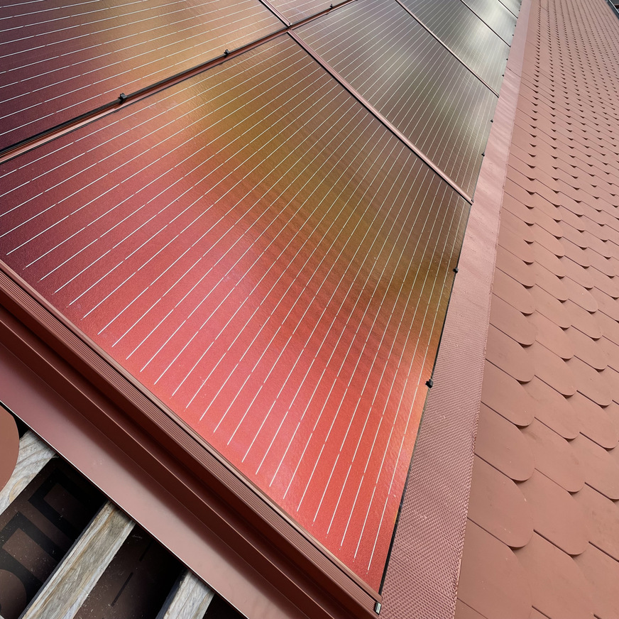Die ziegelrote Photovoltaik-Anlage wurde in das Dach integriert.