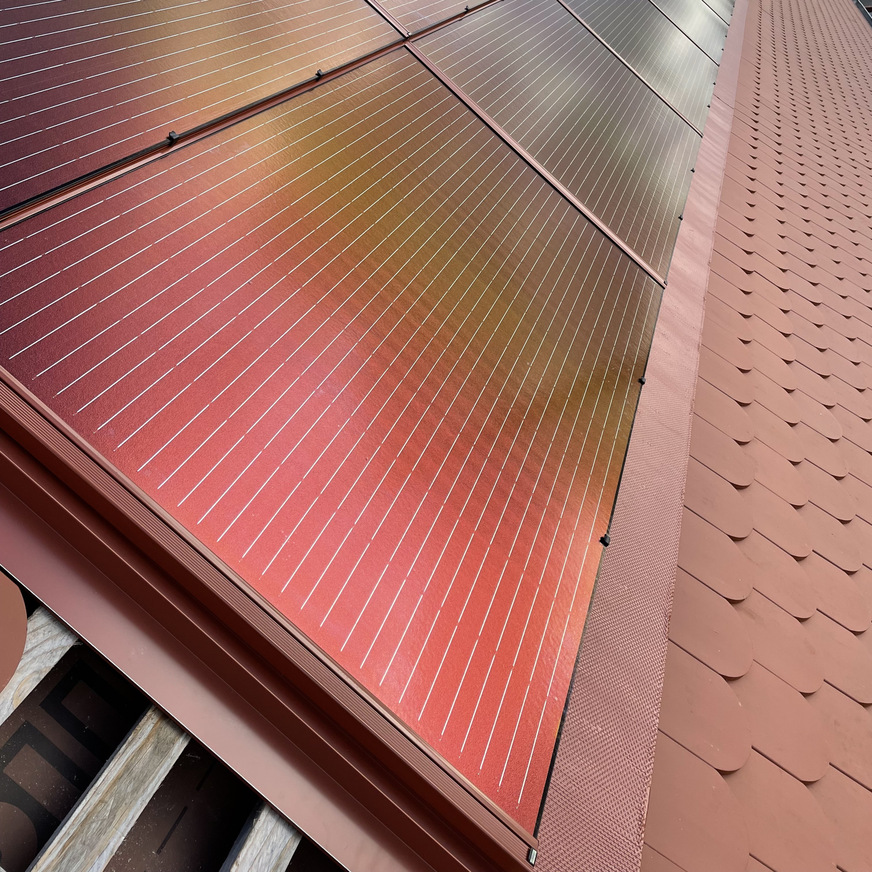 Die ziegelrote Photovoltaik-Anlage wurde in das Dach integriert.