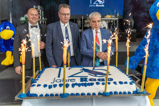 Die Geburtstagstorte schnitt Michael Heraeus an, Gesellschafter und Beiratsvorsitzender der Raab-Gruppe (re.).&nbsp;Mit dabei: Rolf Wagenfeld (Mitte) und Alexander Root (li.).