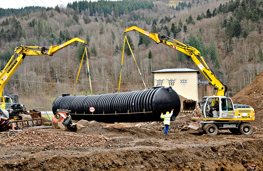 Bild 1 Die Löschwasserbehälter wurden mit zwei Schaufelbaggern an den mitgelieferten Halteschlaufen eingehoben.