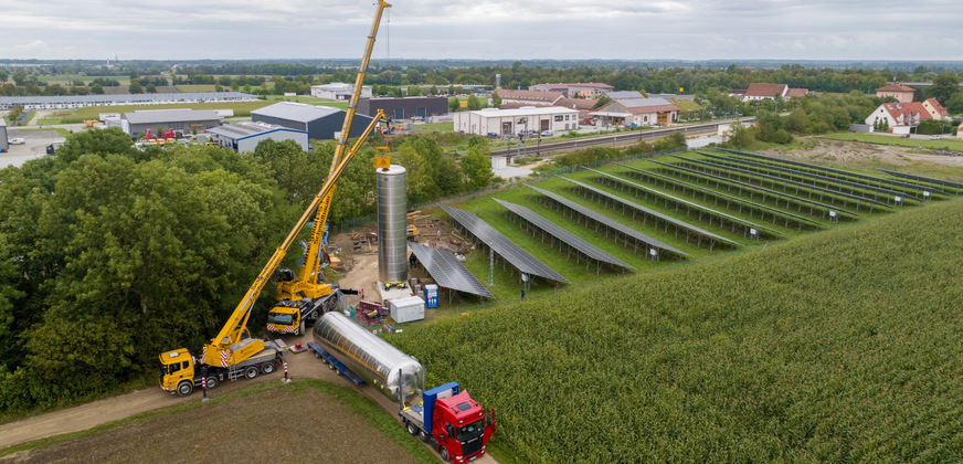 Anlieferung und Aufstellung der beiden 84-m3-Pufferspeicher. Sie speichern künftig die von der Wärmepumpe in Kombination mit der Photovoltaik-Freiflächenanlage erzeugte Wärme für Tageszeiten, in denen keine oder nur wenig Sonne scheint.