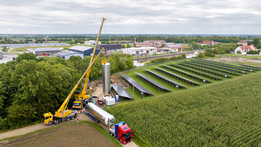 Bild 1 Anlieferung und Aufstellung der beiden 84-m3-Pufferspeicher. Sie speichern künftig die von der Wärmepumpe in Kombination mit der Photovoltaik-Freiflächenanlage erzeugte Wärme für Tageszeiten, in denen keine oder nur wenig Sonne scheint.