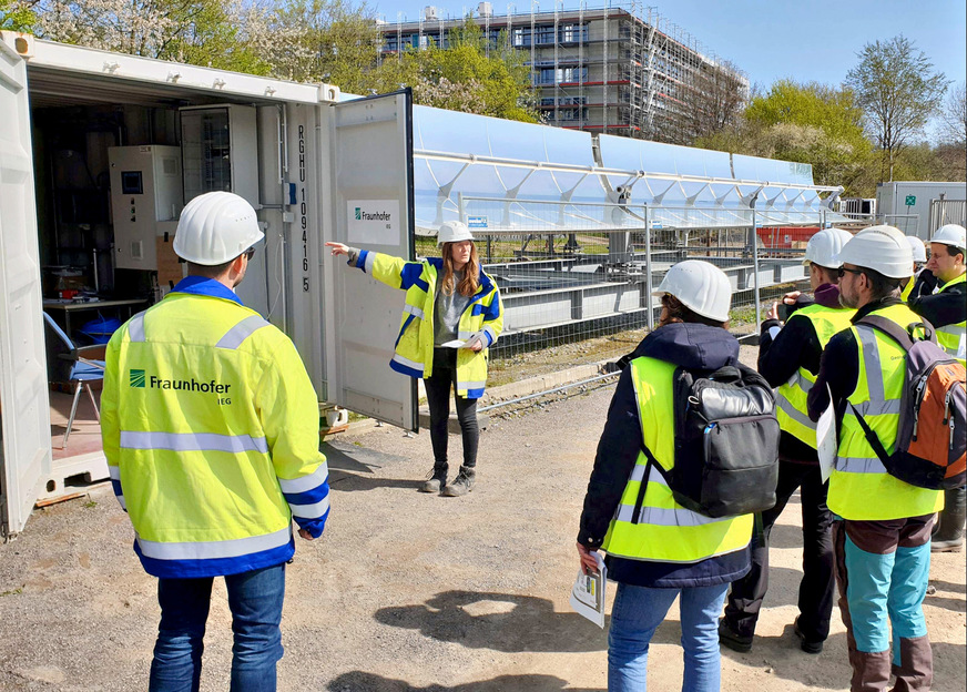 Die leitende Projekt-Ingenieurin Arianna Passamonti erläutert Besuchern die Solarthermie-Anlage. Ihre im Sommer gesammelte Wärme wird im Grubenwasser gespeichert.