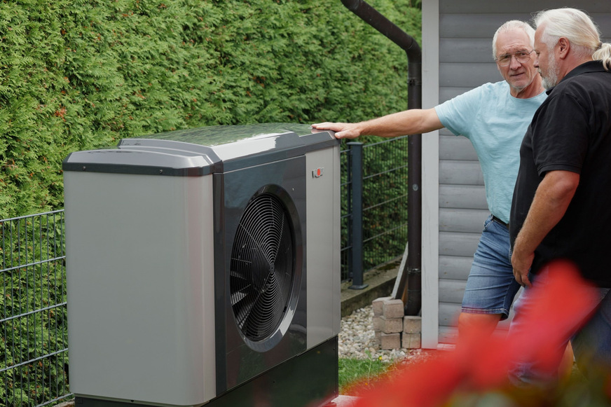 Bild 2 Bauherr Josef Wimmer und Systembau-Geschäftsführer an der bewusst knapp ausgelegten Monoblock-Luft/Wasser-Wärmepumpe CHA-7.