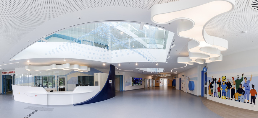 Bild 2 Der Eingangsbereich ist einer Wasserwelt nachempfunden. Die Besucher werden von einem interaktiven Aquarium und einer beeindruckenden Deckeninstallation empfangen. Sie besteht aus 3500 Glaskugeln, die Kinder gestaltet haben und die die Form eines Fischschwarms bilden.