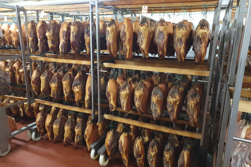 Bild 2 Die Schinkensalzerei und Räucherei August Meschede ist seit Generationen bekannt für hochwertige Schinkenprodukte, insbesondere den 7,5 Monate gereiften Sauerländer Bauern-Knochenschinken.