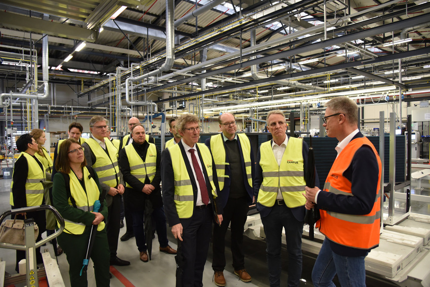 Dr. Kai Schiefelbein erläutert der Besuchergruppe verschiedene Stationen des Fertigungsprozesses einer Wärmepumpe.