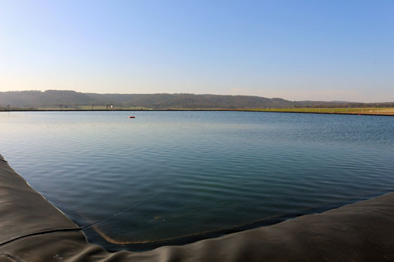 Zentraler Bestandteil des klimaneutralen Wärmekonzepts: 26.600 m3 aufbereitetes Heizungswasser im Erdbeckenspeicher in Bracht. Das VDI-konforme Wasser speist das Nahwärmenetz und stellt die Wärmeversorgung auch bei geringer Sonneneinstrahlung sicher.