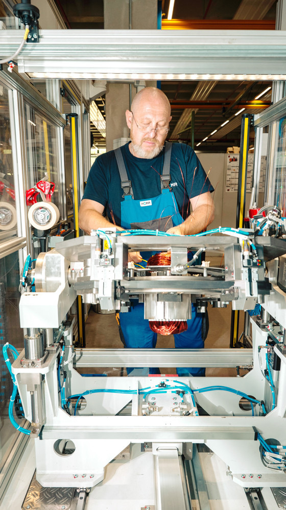 Die Qualität der Motorwicklungen hat oberste Priorität. Ergänzend zu den vollautomatisierten Prozessen des Wickeleinziehzentrums führt der Mitarbeiter eine Sichtkontrolle der Wicklungen durch und bereitet sie für die nachfolgenden Arbeitsgänge vor.