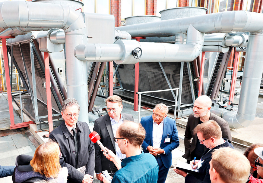 Bild 2 Für das Pallasseum wird die Abwärme eines benachbarten Rechenzentrums der Deutschen Telekom genutzt. Eine große Wärmepumpe wurde direkt auf dem Dach des Rechenzentrums installiert und hebt die Wassertemperatur auf 70 bis 75 °C.