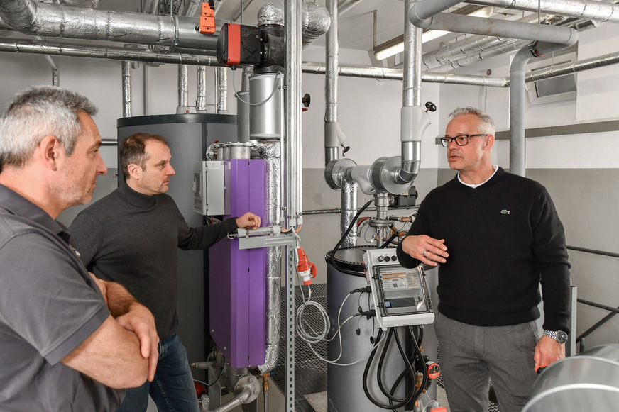 Bild 1 Christian Schober, verantwortlich für die HKL-Haustechnik im Bezirkskrankenhaus (BKH) Kaufbeuren, Betriebsleiter Matthias Maschke und Watercryst-Key-Account-Manager Torsten Schmidt (v. l.) im Gespräch über den Nachhaltigkeitseffekt von chemiefreiem Kalkschutz im BKH.