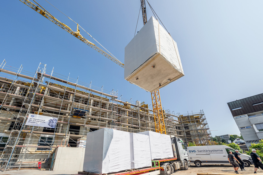 Serielles Bauen mit Fertigbädern erfordert eine präzise Planung und Logistik: Die Module werden noch vor dem Betonieren der Decken per Kran in den Rohbau eingesetzt.