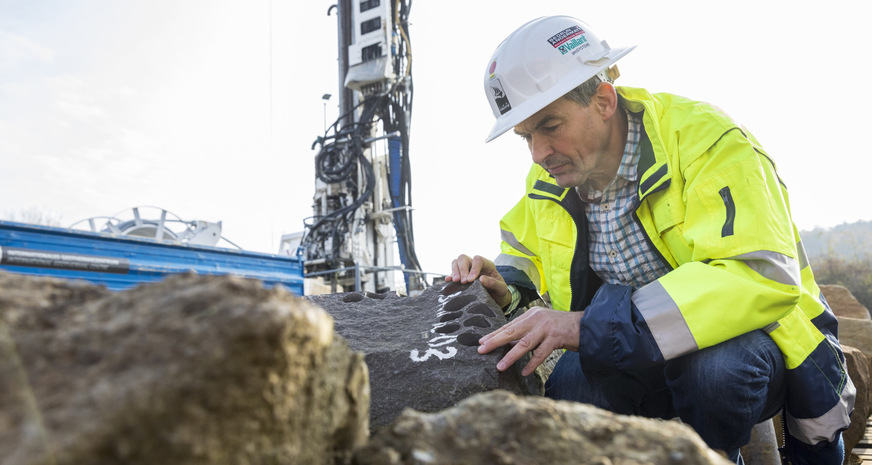 Bild 5 Gesteinsproben auf dem Bohrplatz des Fraunhofer IEG in Bochum werden von einem Mitarbeiter inspiziert.