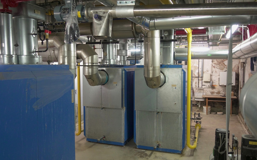 Bild 6 Bisherige Heizzentrale. Die Wärmeversorgung für das Nahwärmenetz oblag drei Gas-Heizkesseln. Die Pelletzuführung für die künftige Wärmeversorgung ist bereits installiert, oben im Bild zu sehen.