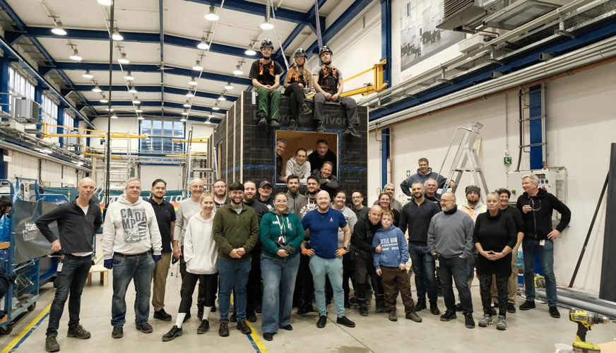 Mit Hilfe der engagierten Kollegen konnte die neueste Version der Holzhäuser von 6 × 2,2 m aufgestellt werden. In der Montagehalle werden üblicherweise Weltraum-Simulationskammern gebaut.