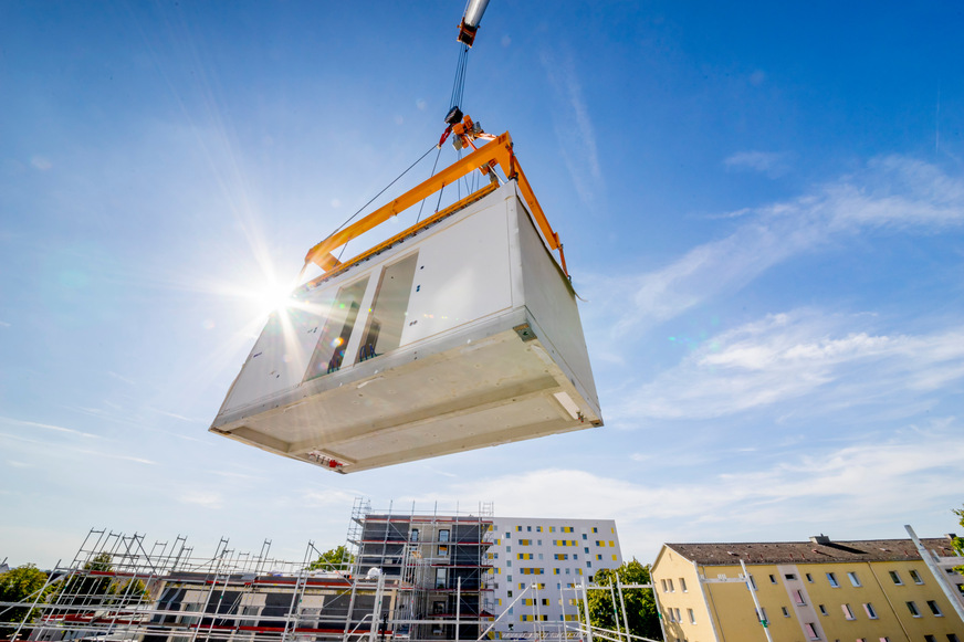 Das Modulsystem von Max Bögl setzt auf serielle Vorfertigung: In der Produktion werden die Module innerhalb weniger Wochen komplett aufgebaut. Auf der Baustelle erfolgt anschließend die Montage, sodass Gebäude in kürzester Zeit schlüsselfertig zur Verfügung stehen.
