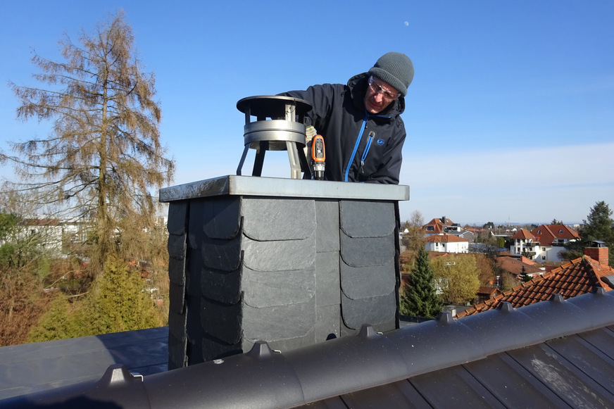 Weit oben und gut geschützt: Wenn Dohlen im Frühjahr einen Nistplatz suchen, wählen die schwarz-grauen Rabenvögel mitunter auch Schornsteine – und verstopfen den Abzug mit Nistmaterial. Für die Hausbewohner ist das eine tödliche Gefahr, warnt das Infocenter der R+V Versicherung.