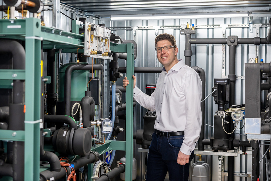 Prof. Simon Klink vor einer Versuchs-Wärmepumpe.
