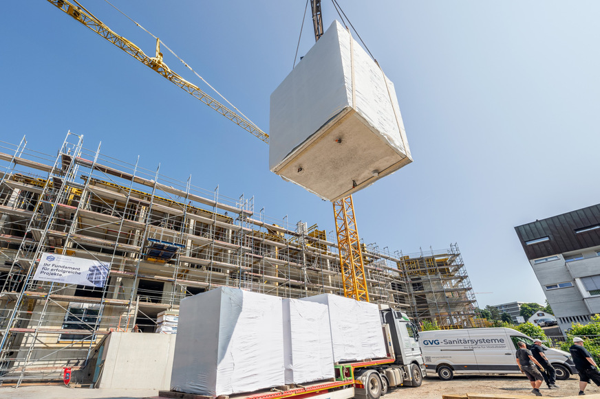 Bild 1 Serielles Bauen mit Fertigbädern erfordert eine präzise Planung und Logistik: Hier werden die Module vor dem Betonieren der Decken per Kran in den Rohbau eingesetzt.