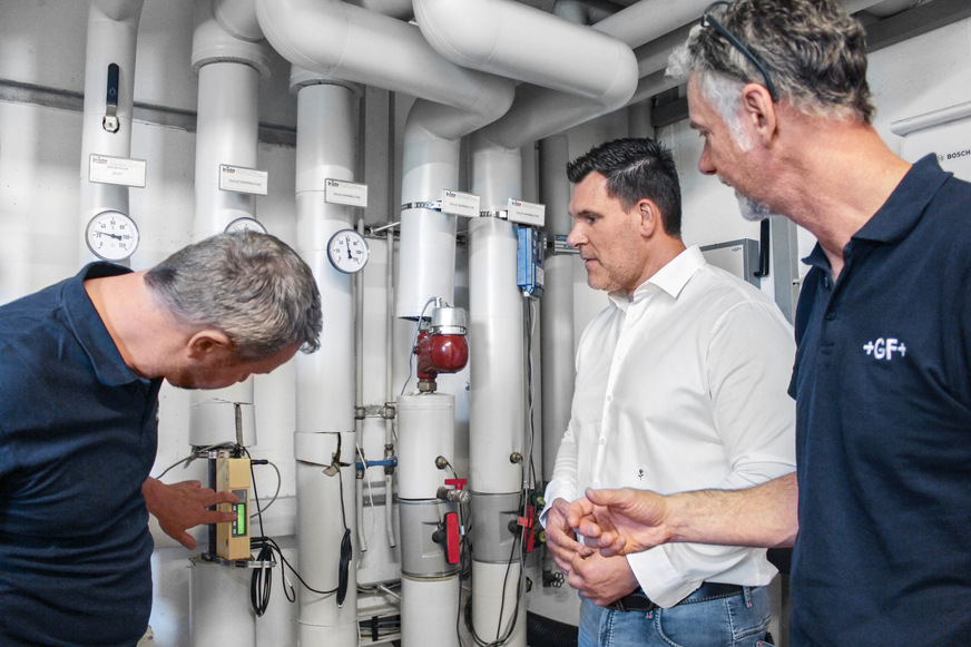 Manuel Kächler (links) und Ralf Schirmer (rechts) erklären Bürgermeister Martin Krämer die Funktionsweise von EcoMate im Heizungskeller der Sixtus-Bachmann-Grundschule in Obermarchtal.