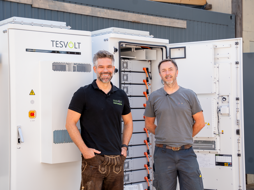Markus Borke, Area Manager bei Tesvolt (links), und Matthias Poeting, Geschäftsführer von MP Elektrotechnik München bei der Installation der Gewerbespeicher auf der Festwiese.