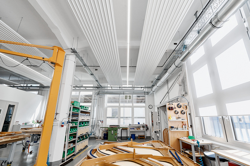 Bild 2 Die ZFP-Deckenstrahlplatten von Zehnder sind neben den Produktionslinien für die Klangkörper auch an den Bearbeitungs- und Umleimarbeitsplätzen installiert. Konstante klimatische Bedingungen beugen Rissen und Verformungen der wertvollen Resonanzkörper aus Buchen- und Mahagoniholz vor.