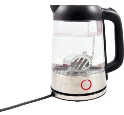 Ein Wasserkocher aus Glas mit einem Teesieb aus Metall, gefüllt mit Wasser, auf weißem Hintergrund.