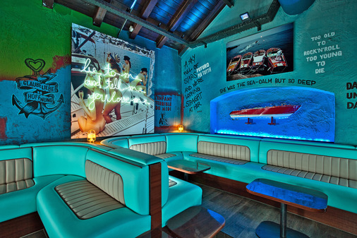In der Riva Bar springt die mediterrane Farbgestaltung des Clubs besonders ins Auge. An den Wänden prangen Graffitis und Aphorismen. 