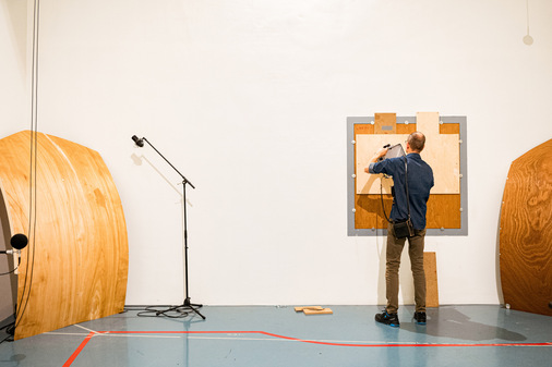 Der sogenannte Hallraum ( reverberation room)  simuliert den Wohnraum. Im Bild wird gerade ein Ventil eingemessen. Hinter der Verbindungswand grenzt der schallgedämmte Raum ( silent room)  an.