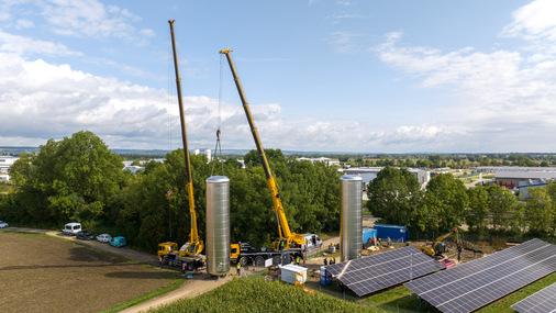 Anlieferung und Aufstellung der beiden 84-m³-Pufferspeicher. Sie speichern künftig die von der Wärmepumpe in Kombination mit der Photovoltaik-Freiflächenanlage erzeugte Wärme für Tageszeiten, in denen keine oder nur wenig Sonne scheint. - © GP Joule
