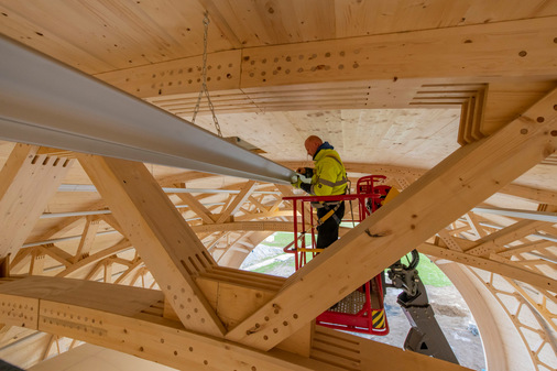 Die schnelle und einfache Montage der leichten Aluminium-Deckenstrahlprofile fast 26 m über dem Boden verringerte im Luftschiffhangar die Installationskosten und die Installationszeit erheblich.  - © WDL Unternehmensgruppe / Foto: Stefan Lamberty
