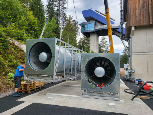  Endmontage des Windkanals im Adlerstadion in Hinterzarten: Die beiden Axialventilatoren von Helios Ventilatoren werden präzise auf die vorbereitenden Fundamente montiert...