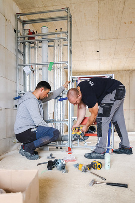 2 Handwerker bei der Montage des Trennwand-Moduls.