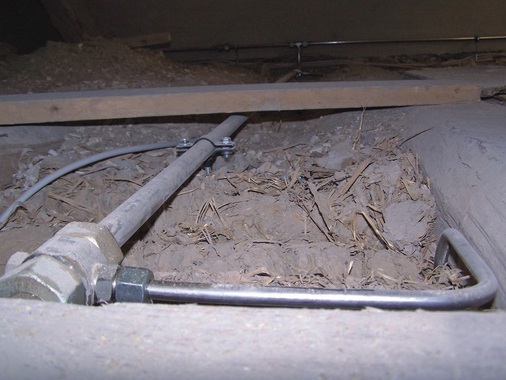 Altbau live: Verteilerleitung mit Sprinklerabgang im Holzfußboden.