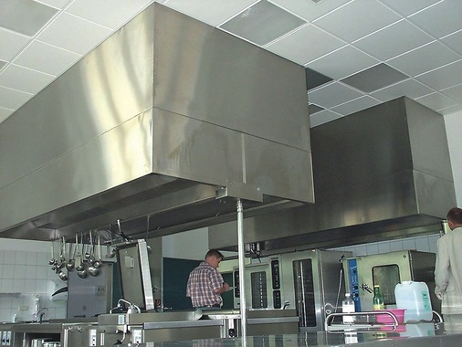 Technik von gestern: Zwei klassische Dunst­abzugshauben in einer ­mittelgroßen Küche. Die Absaugstellen liegen fest und lassen sich nicht verändern. - © Rentschler Reven
