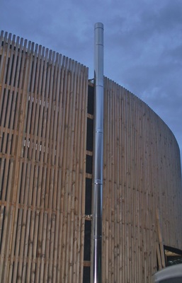 Um den Anschluss der Festbrennstoff-Feuerstätten zu ermöglichen, wurden zwei Edelstahlschornsteine der Bauart DW-ALKON von Raab installiert. Wanddurchführung mit vorgefertigtem WanddurchführungsElement. Die Montage der Schornsteine erfolgte mittels Abstandhaltern parallel zur Holzfassade.