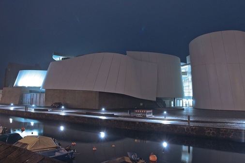 Das Ozeaneum Stralsund vor den Toren Rügens. Die vorgesetzte Fassade aus weiß lackierten Stahlelementen aus dem Schiffsbau symbolisiert “geblähte Segel“ und hat sich als sommerlicher Wärmeschutz bereits bestens bewährt. Foyer mit Wal-Skelett. Die Klimatisierung der Ausstellungshallen erfolgt auch in Abhängigkeit der Besucheranzahl.